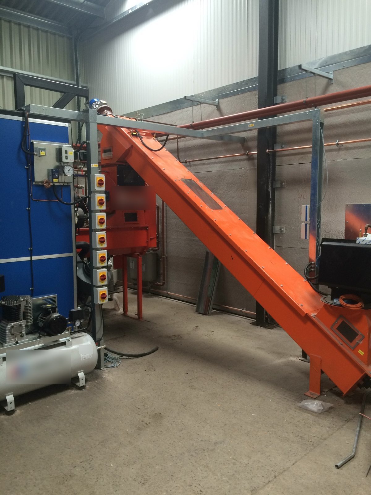 Inclined conveyor feeding fuel up into the biomass boiler