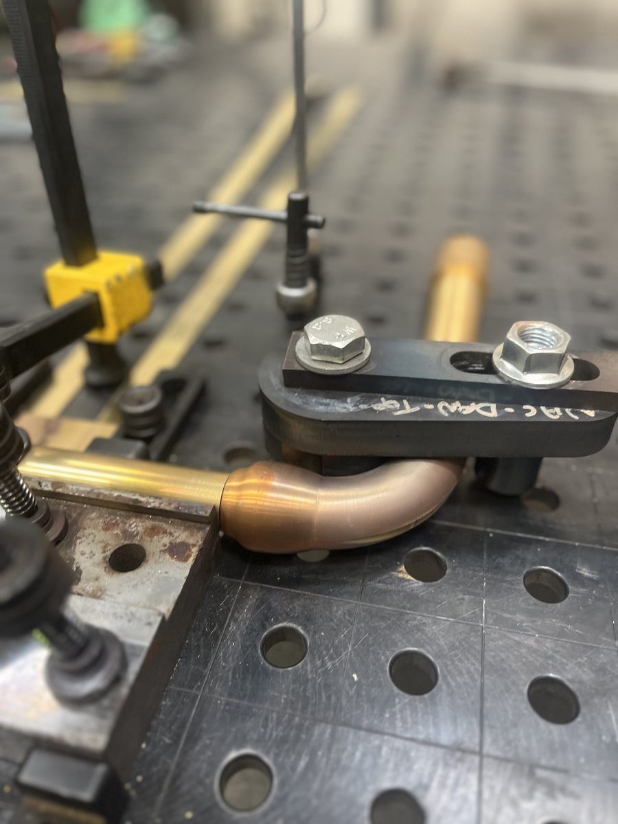 Welding jig holding a brass leg during fabrication